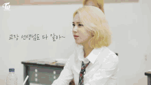 a group of girls are sitting at desks in a classroom with a twice logo on the bottom