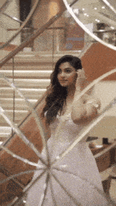 a woman in a white dress stands in front of a mirror