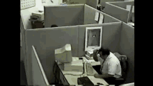 a man is sitting at a desk in front of a computer monitor .