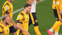 a group of soccer players wearing yellow jerseys that say betss