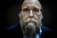 a man with a beard wearing glasses and a blue shirt