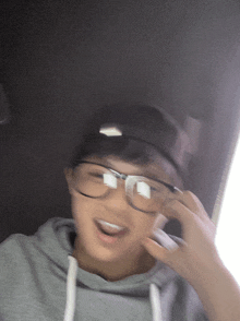 a young boy wearing glasses and a baseball cap