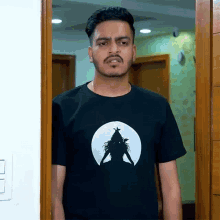a man wearing a black shirt with a silhouette of a woman in a circle