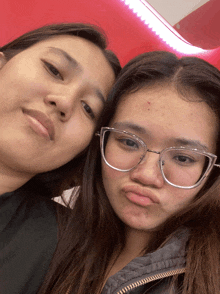 two girls wearing glasses are posing for a photo