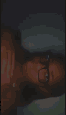 a woman wearing glasses is taking a selfie in a dark room