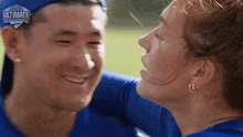 a woman kisses a man on the cheek in front of a sign that says " ultimate challenge "