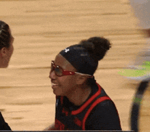 a female basketball player wearing sunglasses and a headband with the letter n on it