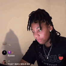 a woman with dreadlocks is wearing a black shirt that says mooul