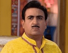 a man wearing a yellow shirt and a mustache is making a funny face .