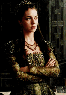 a woman wearing a green and gold dress and a tiara
