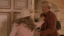 a man is kissing a woman on the cheek in a room .