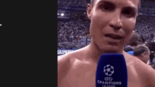 a shirtless man is talking into a champions league microphone