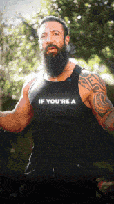 a man with a beard wears a tank top that says if you 're a