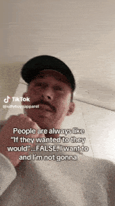 a man with a mustache is wearing a black hat and a grey sweater with a tiktok caption