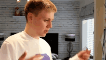 a young man wearing a white shirt with a purple graphic on it