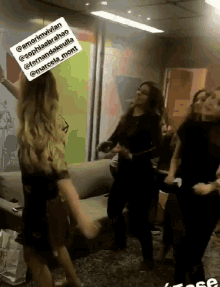 a group of women are dancing in a room with a sign above them that says amorimvivien