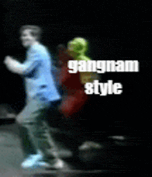 a man in a blue shirt is dancing with a woman in a red dress and the words gangnam style on the bottom