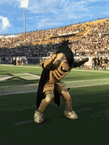 a mascot in a knight costume is dancing on a field