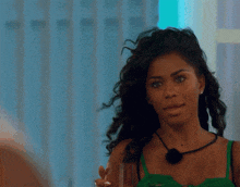 a woman in a green top is holding a glass of wine