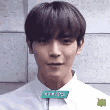 a young man wearing a white shirt and tie is looking at the camera .