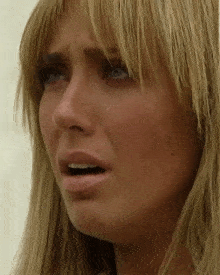 a close up of a woman 's face with a tear running down her cheek