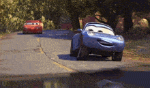 two cars from the movie cars are driving down a street