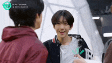 a group of young men are standing next to each other and talking .