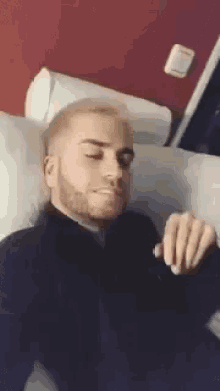 a man with a beard is laying in a hospital bed .