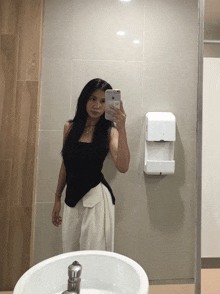 a woman taking a picture of herself in a bathroom