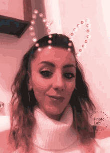 a woman is wearing a heart shaped headband with pearls