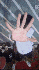 a person holding up their hand in front of a wall that has the number 8 on it