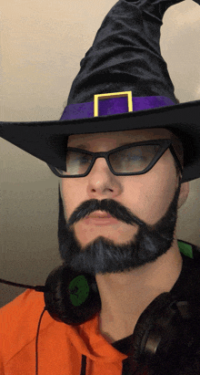 a man with a beard and mustache wearing a witch hat and glasses