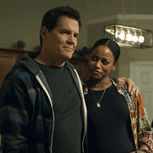 a man and a woman standing next to each other in a dark room
