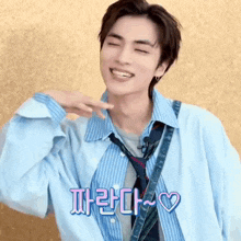 a young man wearing a blue shirt and tie is smiling and making a face .