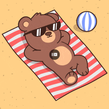 a teddy bear wearing sunglasses is laying on a towel on the beach