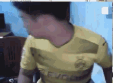 a man is wearing a yellow shirt that says peugeot