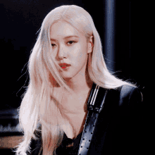a woman with long blonde hair is wearing a black suit