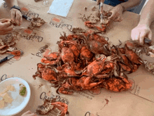 a pile of crabs on a table with crab place written on the table cloth