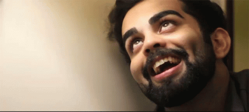 a man with a beard and mustache is smiling and looking up