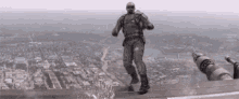 a man in a military uniform is standing on top of a building in the air .