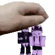 a hand is holding a purple toy robot on top of another toy robot .