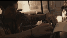 a man sitting at a table with a bottle of evian water