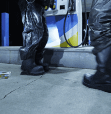 a person standing in front of a gas pump that says ' fuel pump ' on it