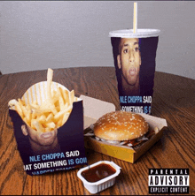 a hamburger and french fries on a table with a parental advisory sticker