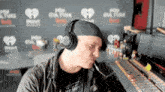 a man wearing headphones stands in front of a pop culture sign