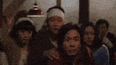 a man with a bandana on his head is being comforted by a group of people