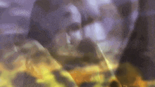 a close up of a person 's face in a blurry photo with a purple background .