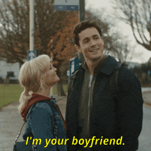 a man and a woman are standing next to each other and the man is saying i 'm your boyfriend