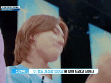 a close up of a person 's face with korean writing on the bottom right corner