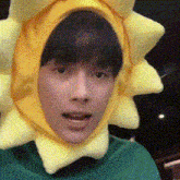 a young man wearing a yellow sun hat and a green shirt .